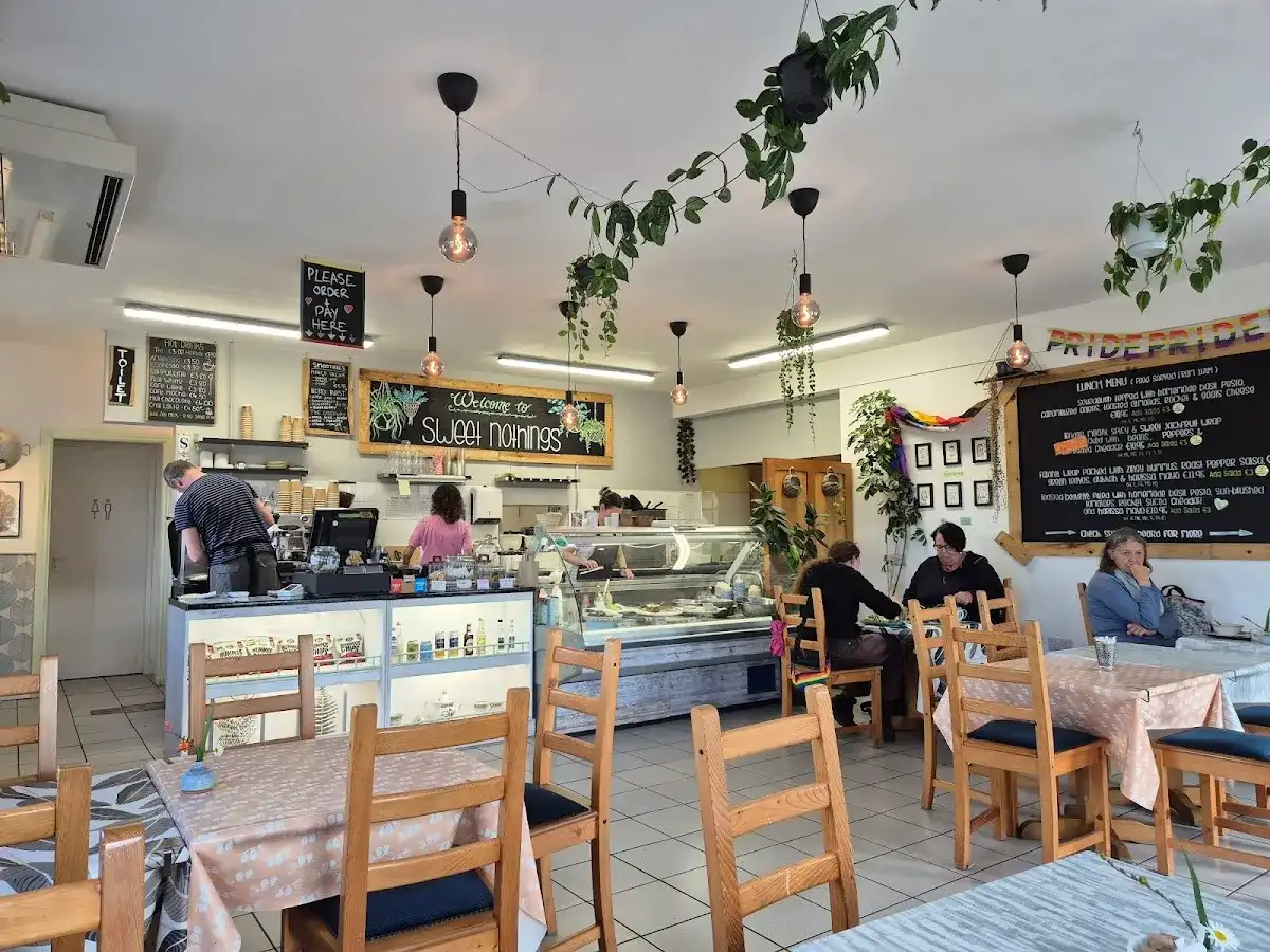Interior with counter, deli case, hanging plants and chalkboard menu